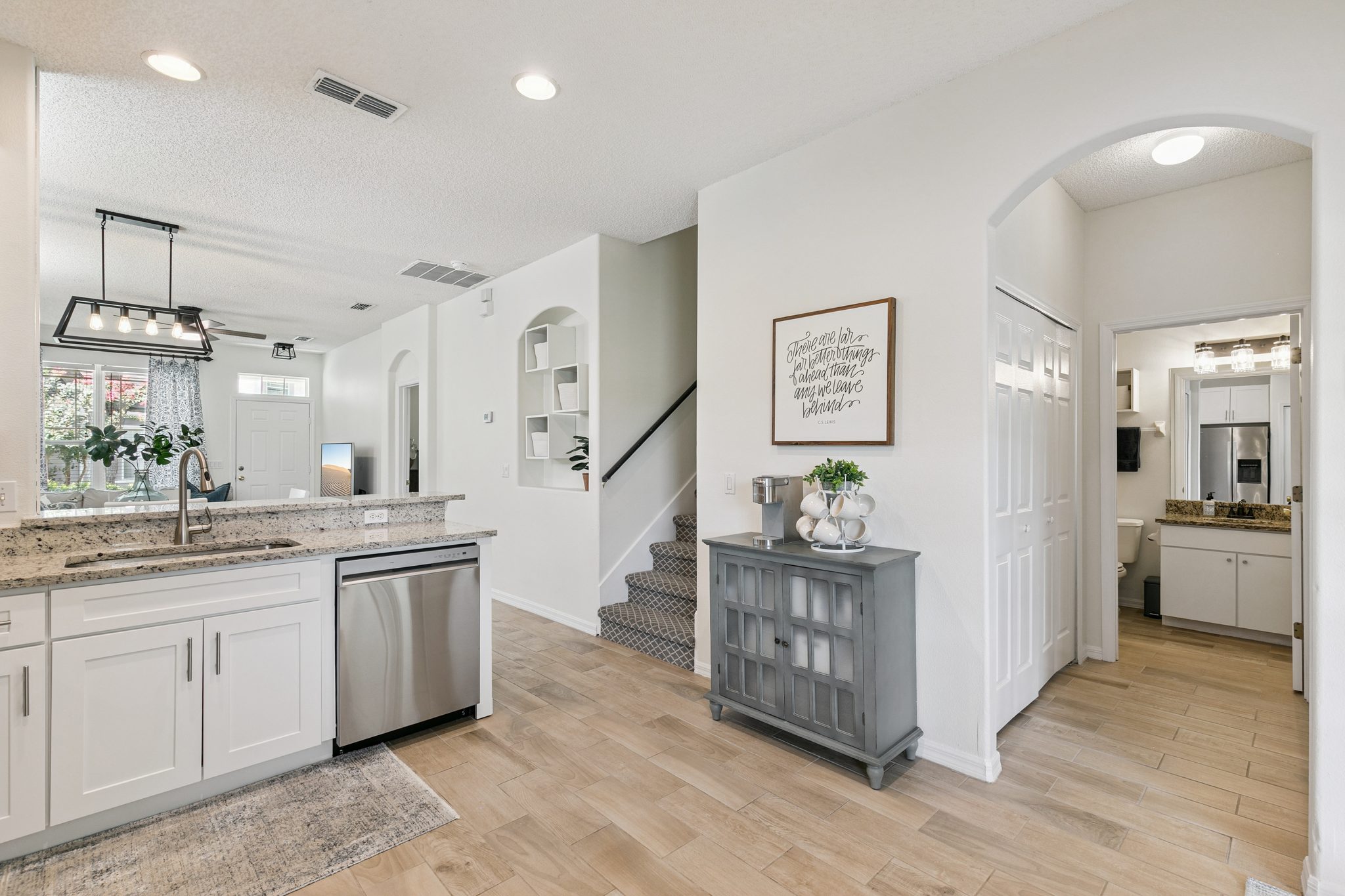 Renovated kitchen with white cabinetry, open to the living area and staircase at 13449 Carroway St, Windermere